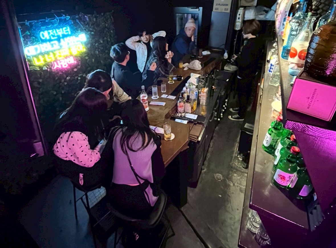 한국바 SARANG 카운터에서 대화하는 남녀 손님과 사랑해 네온